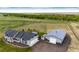 Aerial view of a well-maintained home with a large outbuilding and a spacious, landscaped yard in a rural setting at 196 W 8Th Ave, Byers, CO 80103