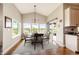 Bright dining room boasts many windows, vaulted ceilings, a wooden table, and an adjacent sliding door to outdoor patio at 196 W 8Th Ave, Byers, CO 80103