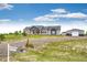 Inviting gray home with red accents, featuring a well-manicured lawn and a detached garage, perfect for country living at 196 W 8Th Ave, Byers, CO 80103