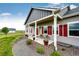 Charming covered front porch with stylish columns, red shutters, and cozy seating, enhancing curb appeal at 196 W 8Th Ave, Byers, CO 80103