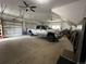 Spacious garage featuring multiple garage doors, ceiling fans, and a large truck parked inside at 196 W 8Th Ave, Byers, CO 80103