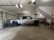Spacious garage featuring multiple garage doors, ceiling fans, and a large truck parked inside at 196 W 8Th Ave, Byers, CO 80103