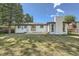 Expansive backyard with a white brick chimney and large mature trees providing shade at 8463 W Arizona Dr, Lakewood, CO 80232