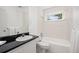 Cozy bathroom with white tiling, a vanity, and a window above the tub at 2921 S Holly Pl, Denver, CO 80222