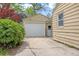 View of detached garage with white door and cracked concrete driveway at 2921 S Holly Pl, Denver, CO 80222