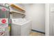 Laundry area featuring a washing machine, dryer, and shelving for storage at 2921 S Holly Pl, Denver, CO 80222