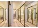 Long bathroom hallway with mirrored closets and light wood flooring at 7925 W Layton Ave # 522, Littleton, CO 80123