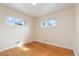 Sunny bedroom features hardwood floors, neutral walls, and two bright windows at 10949 E 109Th Pl, Northglenn, CO 80233