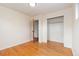 Bright bedroom featuring hardwood floors, neutral walls, and a closet for ample storage space at 10949 E 109Th Pl, Northglenn, CO 80233