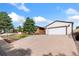 Large concrete driveway leads to a detached two-car garage with a white door at 10949 E 109Th Pl, Northglenn, CO 80233