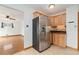 Kitchen featuring stainless steel refrigerator, wooden cabinetry and view into connecting room at 10949 E 109Th Pl, Northglenn, CO 80233