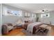 Cozy main bedroom featuring hardwood floors, modern furnishings, and bright windows at 10949 E 109Th Pl, Northglenn, CO 80233