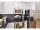 Modern kitchen features dark backsplash, stainless steel appliances, and plenty of cabinet space at 1044 Rockhurst Dr # 207, Highlands Ranch, CO 80129
