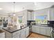 Open kitchen view with a large window, island, and white cabinetry at 1044 Rockhurst Dr # 207, Highlands Ranch, CO 80129