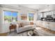 Well-lit living room with natural light, an open kitchen view, and modern decor at 1044 Rockhurst Dr # 207, Highlands Ranch, CO 80129