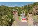Aerial view of two homes on a hillside, surrounded by lush greenery and trees at 12135 Cochise Cir, Conifer, CO 80433
