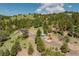 Aerial view showcasing two homes situated on a wooded hillside, with a winding driveway at 12135 Cochise Cir, Conifer, CO 80433