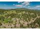 Scenic aerial view of a rural landscape, featuring homes nestled among the trees on a hillside at 12135 Cochise Cir, Conifer, CO 80433