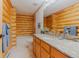 Bright bathroom featuring log walls, granite countertops, and a shower over the tub at 12135 Cochise Cir, Conifer, CO 80433