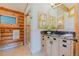 Bathroom featuring log walls, tiled floors, a glass shower, and modern vanity at 12135 Cochise Cir, Conifer, CO 80433