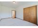 An airy bedroom with neutral carpet, wood trim, and double door closet storage at 12135 Cochise Cir, Conifer, CO 80433