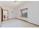 A white bedroom with a large window with a mountain view and an open doorway at 12135 Cochise Cir, Conifer, CO 80433