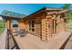 Exterior view of deck area with seating and log cabin walls at 12135 Cochise Cir, Conifer, CO 80433