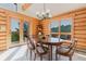 Dining room features a wood table, six chairs, log walls, and access to the outside deck at 12135 Cochise Cir, Conifer, CO 80433