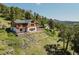 Sprawling log cabin with multiple balconies, terraced landscaping, and scenic views at 12135 Cochise Cir, Conifer, CO 80433