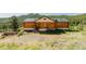 Cozy log cabin featuring a quaint porch and surrounded by lush greenery with mountain views at 12135 Cochise Cir, Conifer, CO 80433