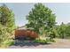 Charming cabin-style home featuring wood siding and a mature tree in the front yard at 12135 Cochise Cir, Conifer, CO 80433