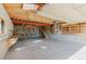 Large garage with concrete flooring, wooden stairs, and storage shelves along the back wall at 12135 Cochise Cir, Conifer, CO 80433