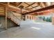 Spacious garage interior with concrete flooring, high ceilings, stairs, and open door at the back at 12135 Cochise Cir, Conifer, CO 80433