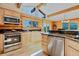 Well-equipped kitchen with stainless steel appliances, light wood cabinetry, granite counters, and log walls at 12135 Cochise Cir, Conifer, CO 80433