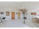 Open studio space with white walls, vaulted ceilings, and wooden door leading to the hallway at 12135 Cochise Cir, Conifer, CO 80433