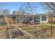 Backyard featuring grey siding home, well-maintained landscaping, and sunroom addition at 755 Newark St, Aurora, CO 80010