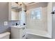Bright, remodeled bathroom featuring updated fixtures and marble tiled walls surrounding tub and shower at 755 Newark St, Aurora, CO 80010