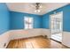 Bright blue bedroom featuring hardwood floors, with light streaming through the window at 755 Newark St, Aurora, CO 80010