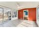 Bright sunroom with large windows, ceiling fan, wood-look floors, and access to the home's exterior at 755 Newark St, Aurora, CO 80010