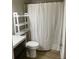 Bathroom featuring a toilet, sink, and shower with white shower curtain, and added white shelving unit for storage at 1415 Bacchus Dr # D9, Lafayette, CO 80026
