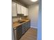 Compact kitchen featuring white cabinets, stainless steel appliances, and modern fixtures at 1415 Bacchus Dr # D9, Lafayette, CO 80026