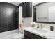 Contemporary bathroom features black tiled walls, a shower-tub combo, and marble vanity at 4028 S Atchison Way, Aurora, CO 80014