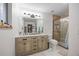 Bathroom featuring dual sinks, modern vanity, updated shower, and natural lighting at 4028 S Atchison Way, Aurora, CO 80014