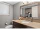 Modern bathroom with a granite countertop, dark wood vanity, updated fixtures, and a mirrored medicine cabinet at 4028 S Atchison Way, Aurora, CO 80014