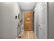 Inviting entryway with wood floors, light gray walls, a stylish console table, and a decorative wooden front door at 4028 S Atchison Way, Aurora, CO 80014