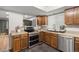 Well-maintained kitchen with stainless steel appliances, wood cabinets, and dark tile flooring at 4028 S Atchison Way, Aurora, CO 80014