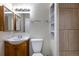 Bathroom featuring a sink, toilet, mirror, vanity, and shower with tiled wall at 11524 Marshall Ct, Broomfield, CO 80020