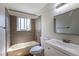 Neutral bathroom featuring a tub with tiled walls, a bright vanity, and a rectangular mirror at 11524 Marshall Ct, Broomfield, CO 80020