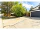 Spacious driveway leading to a two-car garage with an adjacent fenced-in yard and mature trees at 11524 Marshall Ct, Broomfield, CO 80020