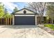 Two-car garage with stone accents and detailed trim work, featuring a well-maintained driveway and landscaping at 11524 Marshall Ct, Broomfield, CO 80020